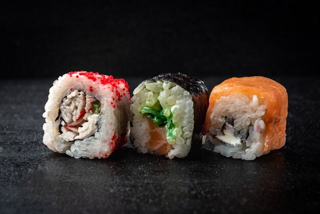 Rollos de sushi sobre fondo negro. Comida japonesa.