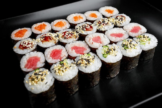 Rollos de sushi en surtido sobre un fondo negro