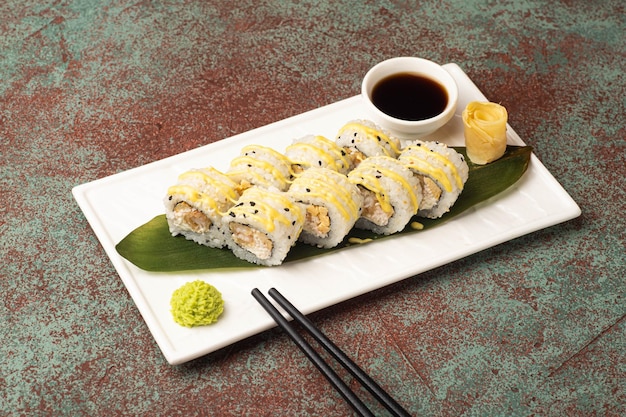 Rollos de sushi sushi con pescado en una vista lateral de fondo texturizado