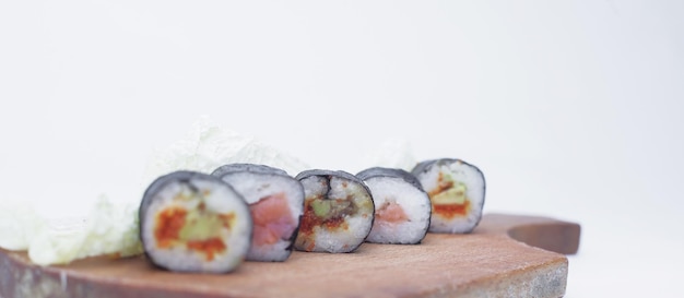 Rollos de sushi en un tablero de corte aislado en blanco