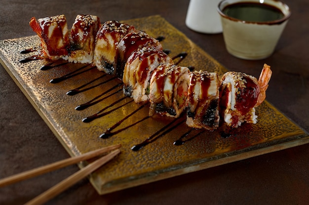 Rollos de sushi tobiko de camarones y pepinos con anguila y salsa unagi