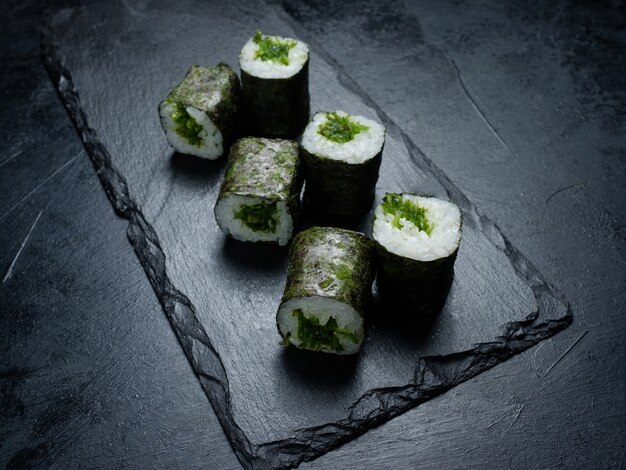 Rollos de sushi vegano sobre fondo oscuro