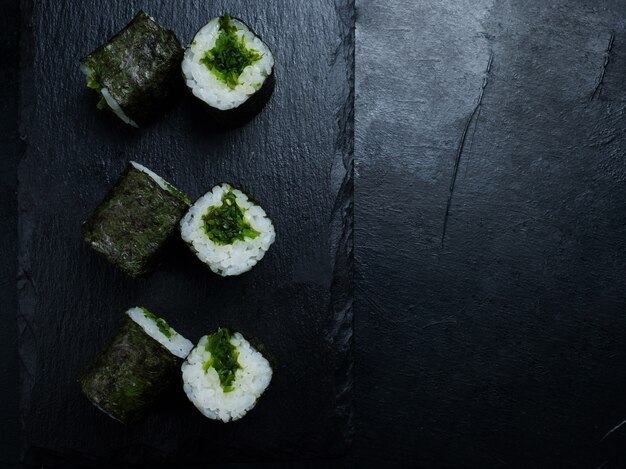 Rollos de sushi vegano sobre fondo oscuro