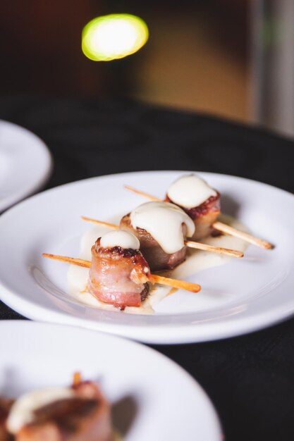 Rollos de tocino cocido perforado con un palo servido en un plato