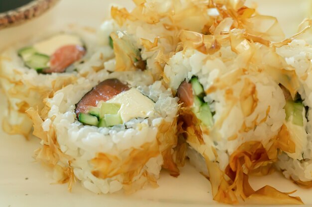 Rollos tradicionales japoneses con salmón, queso y hojuelas de atún ahumado