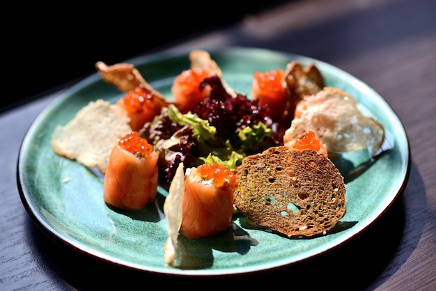 Rolls com salmão, queijo, caviar vermelho e bolachas