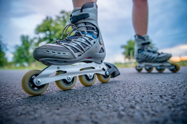 Rollschuhe in Aktion auf dem Asphaltweg bei Freestyle-Rennen außerhalb der Stadt