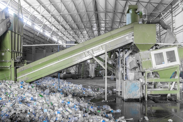 Rolltreppe mit einem Haufen Plastikflaschen im Werk zur Verarbeitung und zum Recycling