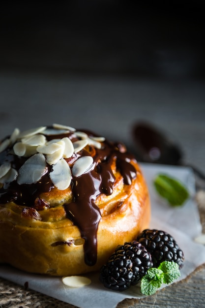 Rolo com chocolate, nozes e frutas, mesa de pedra escura