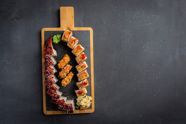 Rolo com enguia defumada, queijo e rúcula. Definir rolo de sushi. Cozinha tradicional japonesa. Isolado em preto.