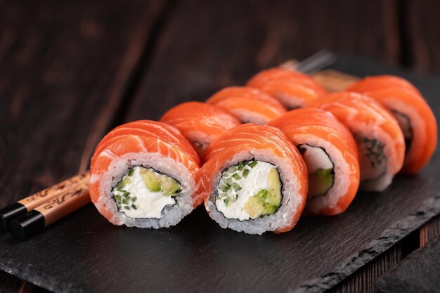 Rolo com sushi de peixe com pauzinhos conceito de comida asiática