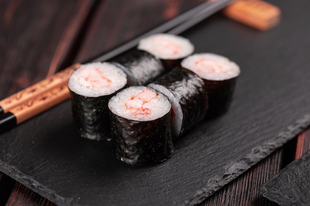 Rolo com sushi de peixe com pauzinhos conceito de comida asiática