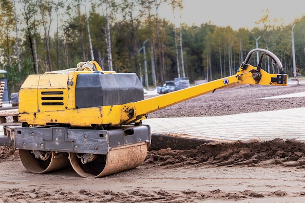 Foto rolo compactador de asfalto manual para compactação de solo em canteiro de obras. obras rodoviárias com o uso de mecanismos.
