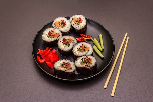 Rolo coreano Gimbap (kimbob). Arroz branco cozido no vapor (bap) e vários outros ingredientes. Fundo preto na moda