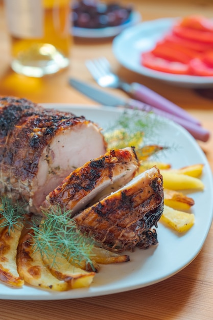 Rolo de carne com especiarias em um prato encontra-se sobre uma mesa.