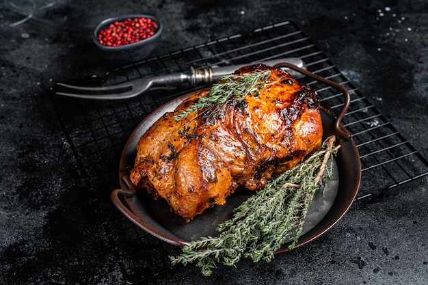 Rolo de carne de porco vitrificada assada com tomilho e molho de tomate Fundo preto Vista superior