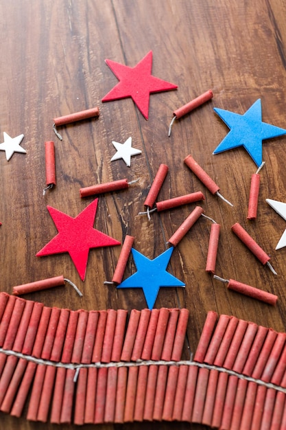 Rolo de fogos de artifício com estrelas vermelhas, brancas e azuis na mesa de madeira.