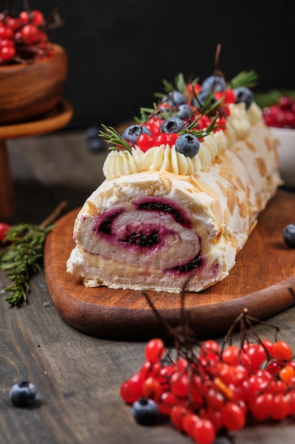 Rolo de merengue de ano novo com morangos mirtilos, framboesas e cranberries