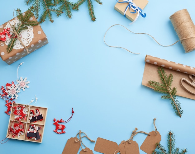 Rolo de papel de embrulho marrom, decoração, ramos de abeto, brinquedos de Natal e caixas com presentes