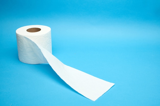 Rolo de papel higiênico branco rasgado em fundo azul minimalista