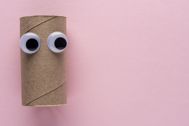 Foto rolo de papel higiênico concluído com olhos arregalados em fundo rosa.