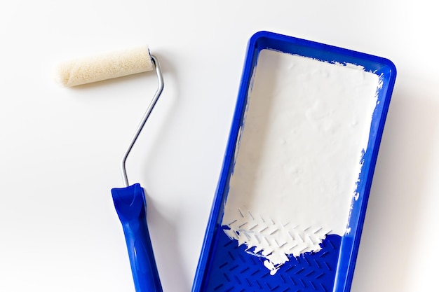 Rolo de pintura e bandeja com pintura branca para renovação e decoração de interiores