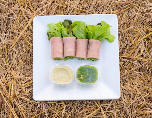 Rolo de salada verde e carvalho vermelho orgânico com recheio de presunto de porco e molho