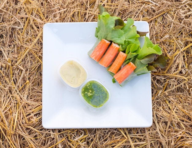 Rolo de salada verde e carvalho vermelho orgânico com recheio Imitação de carne de caranguejo e molho