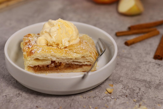 rolo de strudel de massa de maçã com canela na mesa de mármore cinza