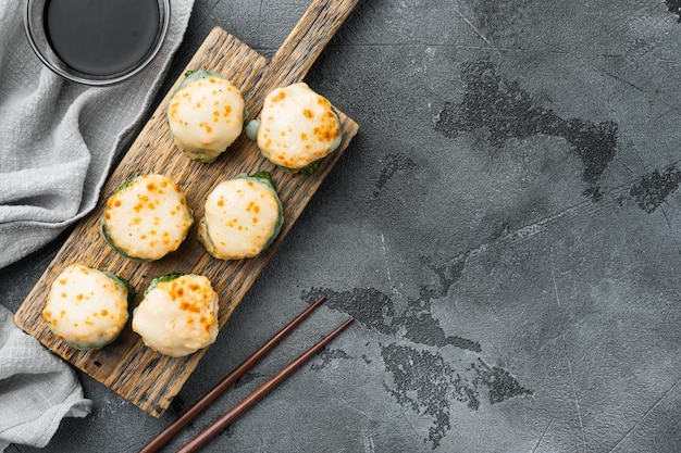 Foto rolo de sushi assado com camarão e tampa de caviar masago prato de restaurante de sushi tradicional em fundo de pedra cinza vista superior plana com copyspace e espaço para texto