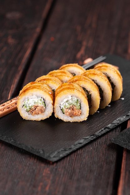 Rolo de sushi com atum fumado com pepino e queijo closeup tradicional delicioso rolo de sushi fresco