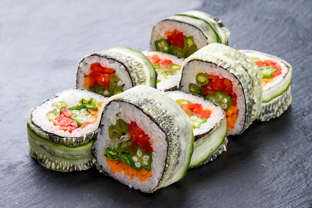 Rolo de sushi com legumes em fundo preto Prato vegetariano