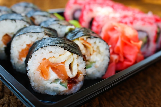 Rolo de sushi com salmão, pepino, queijo e peixe caviar