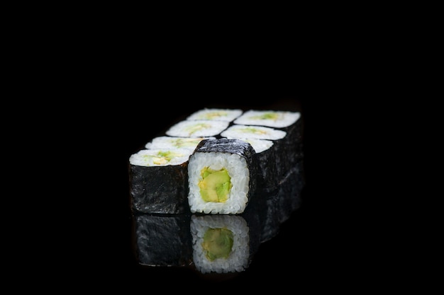 Foto rolo de sushi em uma reflexão de parede preto. comida japonesa fechar-se.