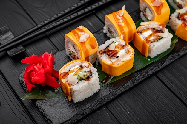 Rolo de sushi fresco delicioso tradicional colocado sobre um fundo preto Rolo de sushi com salmão de queijo creme de arroz