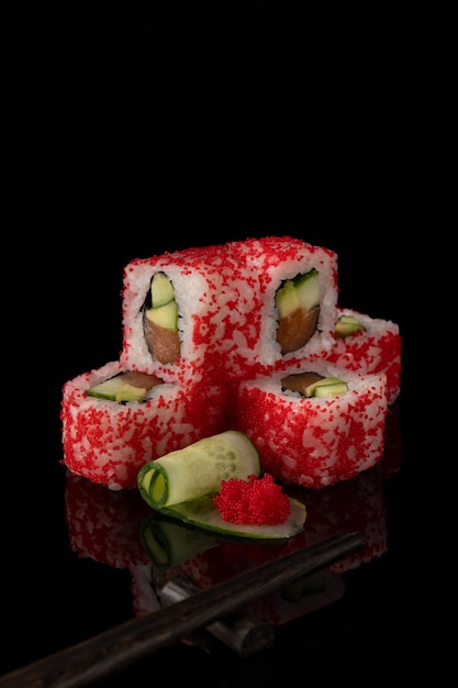 Rolo de sushi fresco delicioso tradicional em um fundo preto com reflexão.
