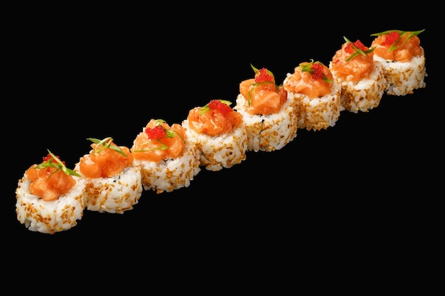 Rolo de sushi japonês com salmão queijo Filadélfia cebola verde tobiko caviar molho AroyD gergelim isolado em fundo preto