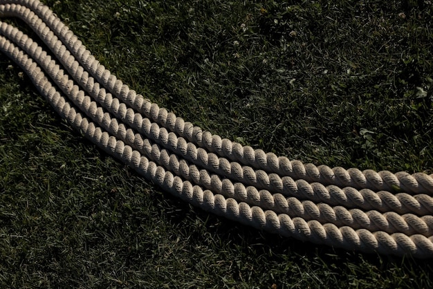 Rolo enrolado de corda disposto no chão de grama