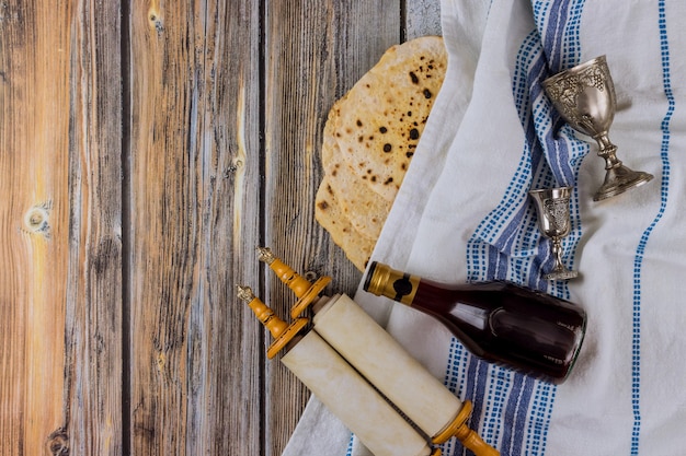 Rolos da Torá judaica em atributos de pesach na composição de vinho e matzá pascal