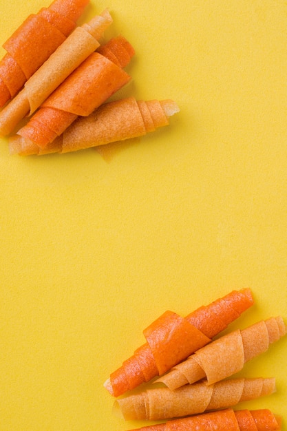 Rolos de frutas de laranja, manga, banana em amarelo. lugar para texto