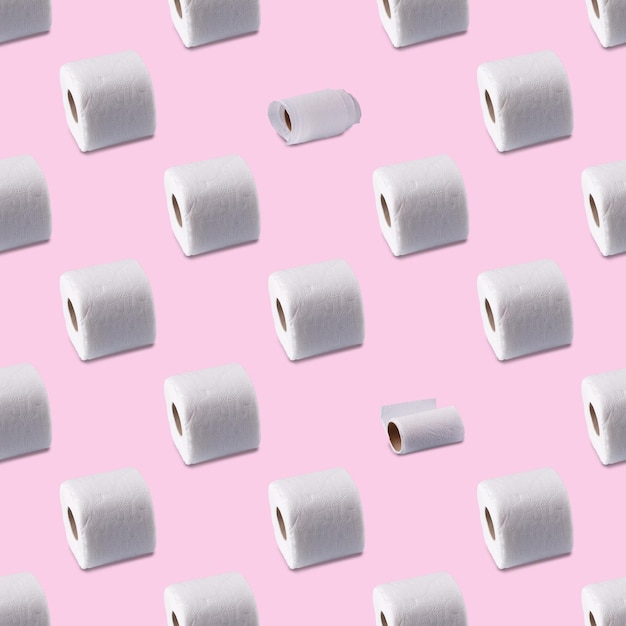 Foto rolos de papel higiênico branco em um padrão sem costura de fundo rosa