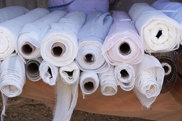 Rolos de seda de tecido branco na loja têxtil