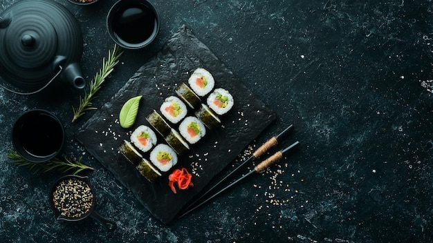 Rolos de sushi com abacate e salmão Sushi japonês clássico Vista superior Espaço livre para o seu texto