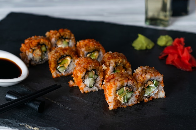 Rolos de sushi com caviar tobiko cheio de creme de queijo e pepino