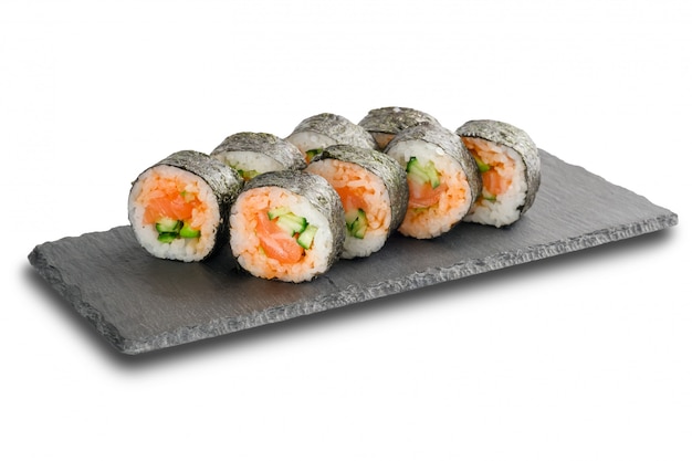 Rolos de sushi com salmão e pepino envolto em folha de nori na superfície de xisto preto ardósia ou pedra isolada no branco