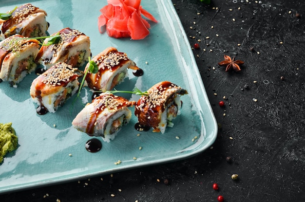 Rolos de sushi com wasabi de enguia e molho de soja comida japonesa Vista superior Estilo rústico