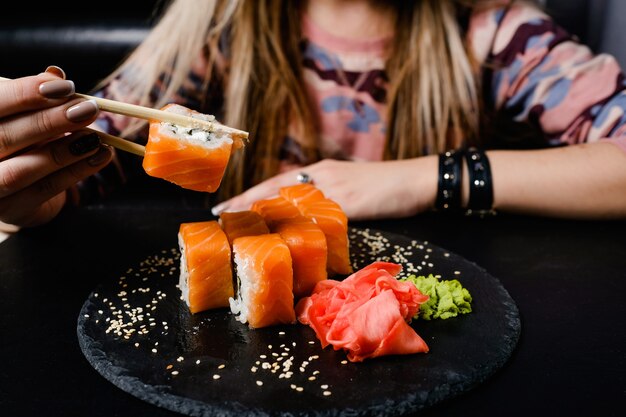 Foto rolos de sushi da filadélfia em fundo escuro. comida asiática. cozinha nacional japonesa.