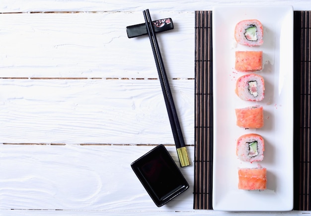 Foto rolos de sushi de salmão em fundo de madeira