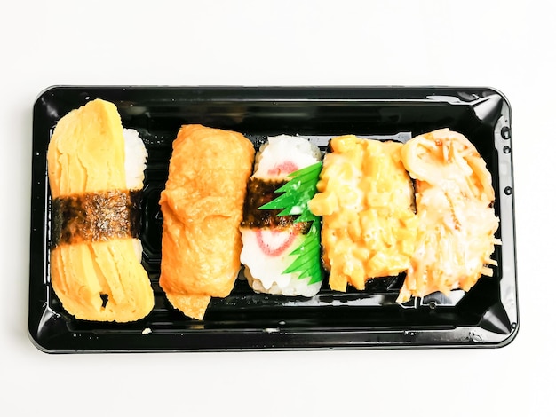 Rolos de sushi em caixa de plástico isolada no fundo branco.