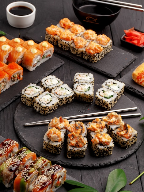 Rolos de sushi em placas coloridas em um fundo preto